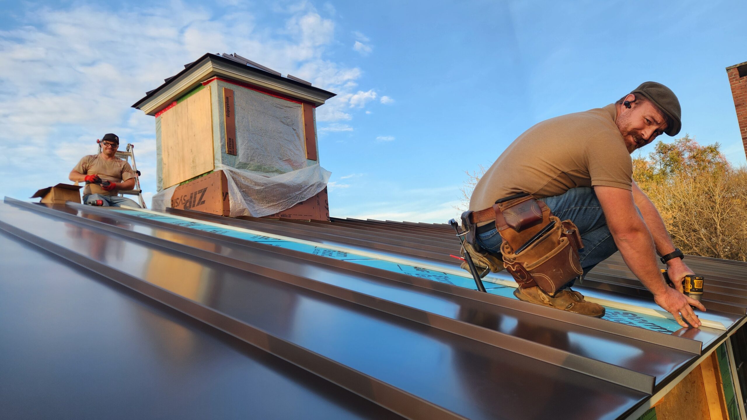 Two men installing a metal roof